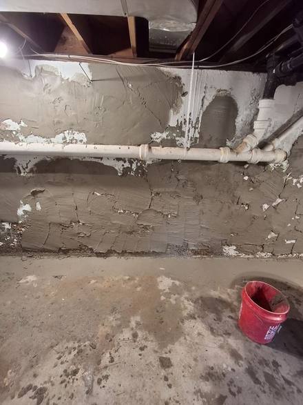 Basement wall with flaking, stained coating