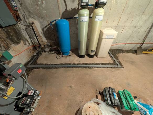 Stone-filled drain trench around water treatment tanks