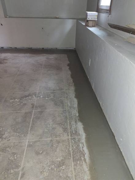 New concrete along the wall where the tile was cut