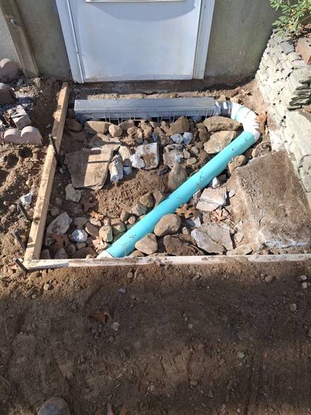 Drain pipe in stone leading to a channel drain at the door