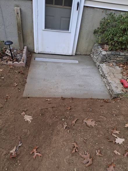 New concrete landing with a channel drain at the basement door