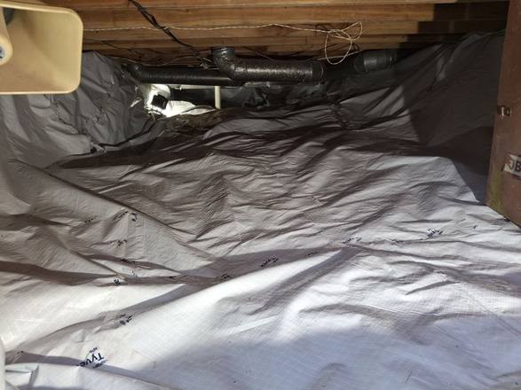 Crawl space covered with a clean white vapor barrier